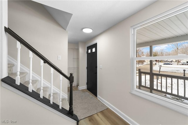 foyer featuring stairway, baseboards, and wood finished floors