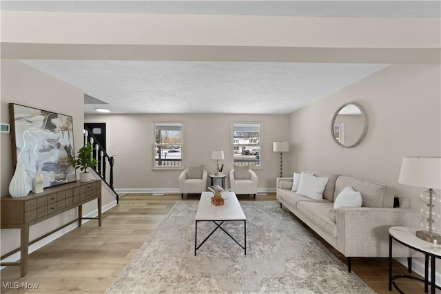 living area featuring stairway, wood finished floors, and baseboards