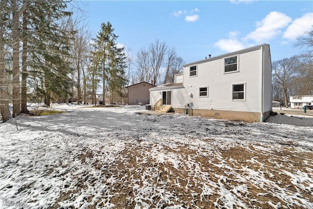 snow covered property with entry steps