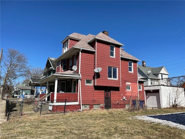 back of property with a yard, fence, and a chimney