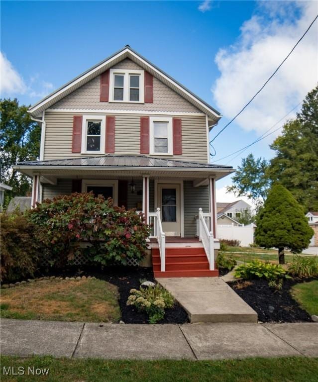 american foursquare style home featuring covered porch