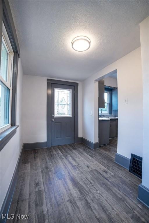 entryway featuring dark wood-style floors, visible vents, and a textured ceiling