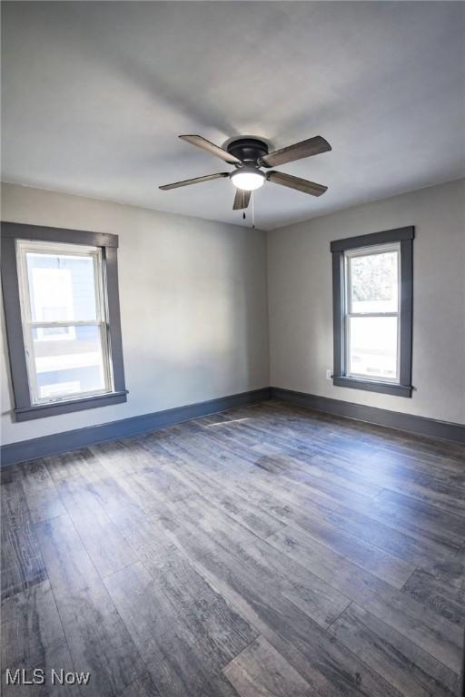 spare room featuring ceiling fan, baseboards, and wood finished floors