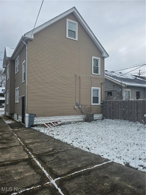 view of snowy exterior featuring fence