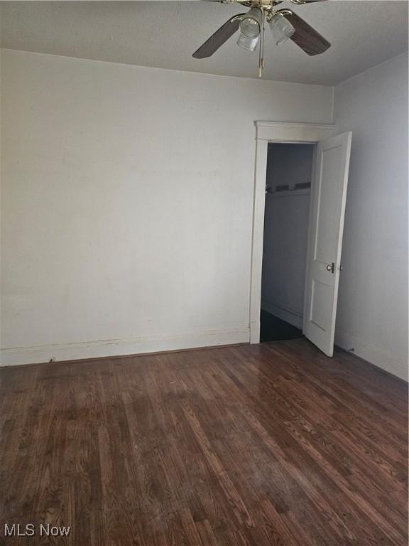 unfurnished bedroom featuring ceiling fan, baseboards, and wood finished floors