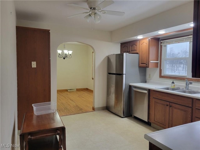 kitchen with visible vents, arched walkways, appliances with stainless steel finishes, light countertops, and a sink