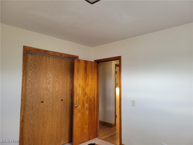 unfurnished bedroom with a closet and wood finished floors