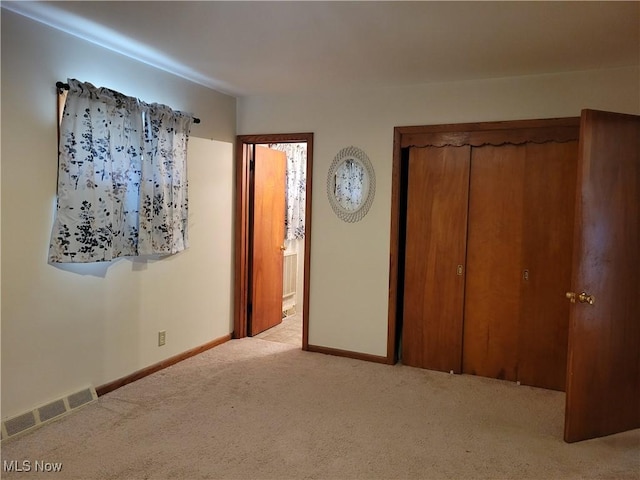 unfurnished bedroom with connected bathroom, carpet flooring, visible vents, and baseboards