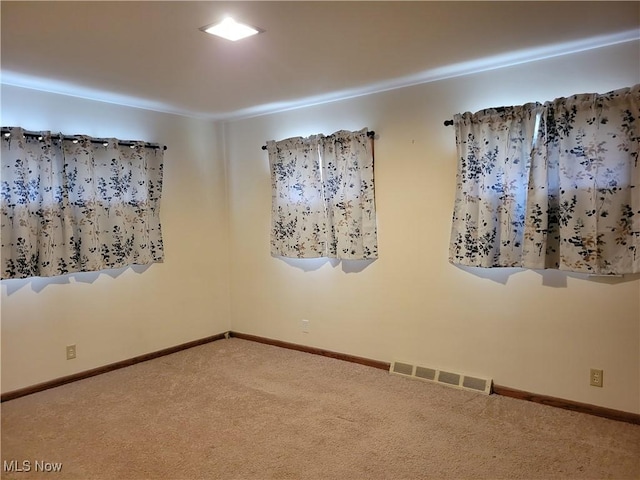 carpeted spare room with baseboards and visible vents