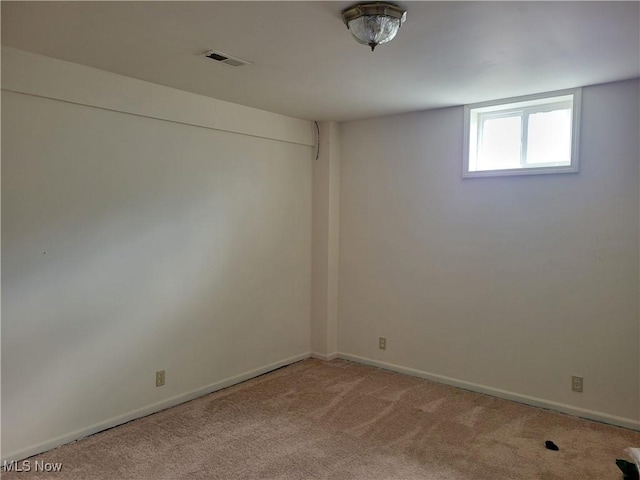 carpeted empty room featuring visible vents and baseboards