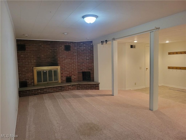 finished basement featuring a brick fireplace, carpet, visible vents, and baseboards