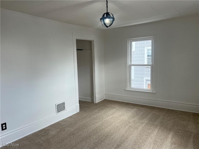 carpeted empty room with visible vents and baseboards