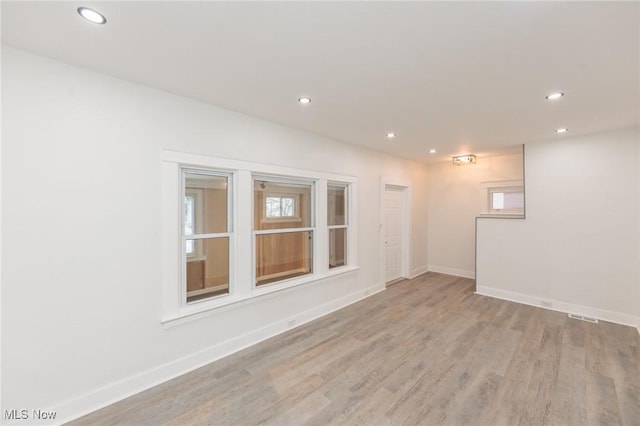 unfurnished room with light wood-style floors, recessed lighting, visible vents, and baseboards