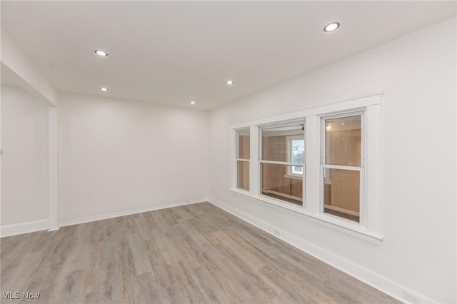 empty room featuring recessed lighting, baseboards, and wood finished floors