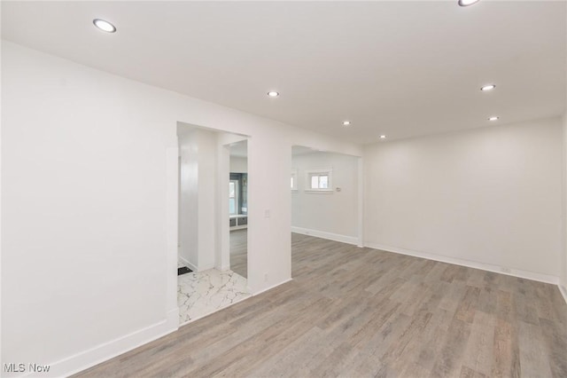 below grade area featuring baseboards, light wood finished floors, and recessed lighting