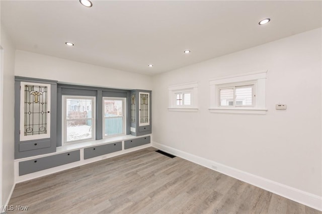 spare room featuring light wood-style flooring, visible vents, baseboards, and recessed lighting