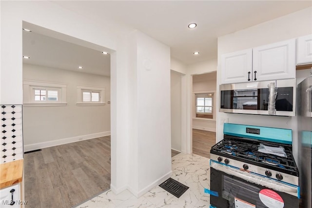 kitchen with visible vents, appliances with stainless steel finishes, white cabinets, and baseboards