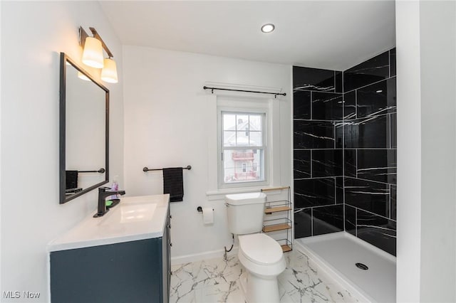 bathroom with baseboards, toilet, marble finish floor, a tile shower, and vanity