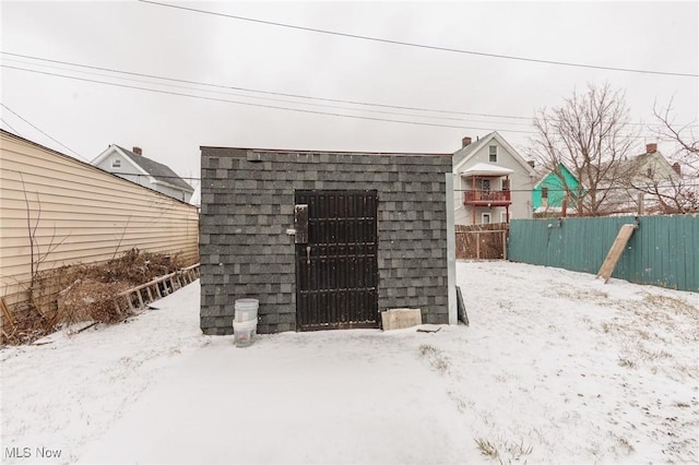 snow covered structure featuring fence