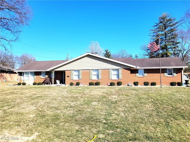 rear view of house with a lawn and brick siding