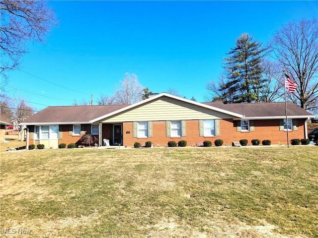 back of property with a yard and brick siding