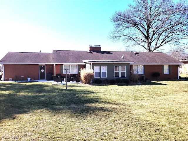 rear view of property with a patio area, a chimney, central AC, and a lawn