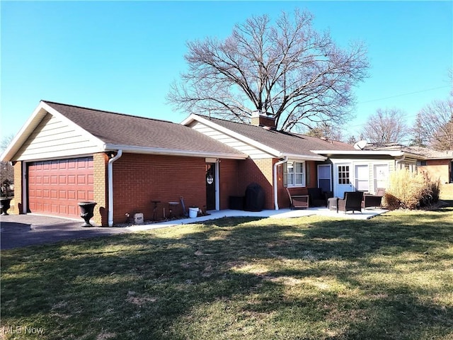 view of home's exterior with a garage, a shingled roof, a lawn, a chimney, and brick siding