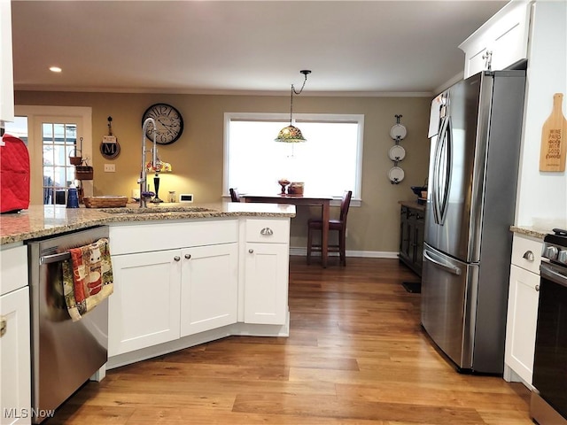 kitchen featuring stainless steel appliances, a sink, white cabinetry, and light wood-style floors