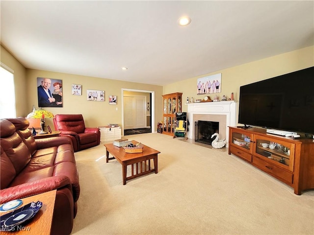 living area featuring a fireplace with flush hearth, carpet flooring, and recessed lighting