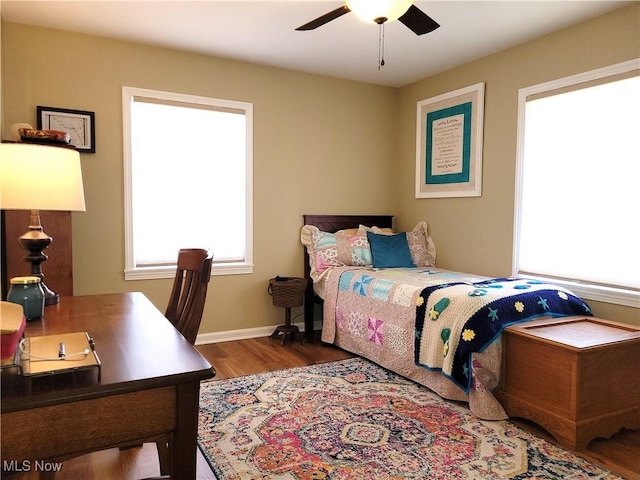 bedroom featuring ceiling fan, baseboards, and wood finished floors