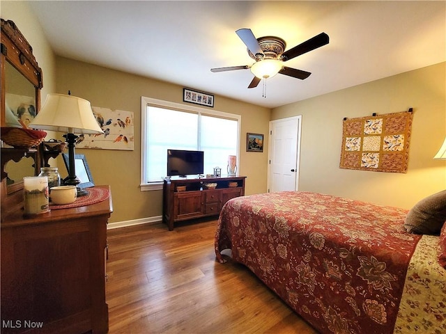 bedroom featuring ceiling fan, baseboards, and wood finished floors