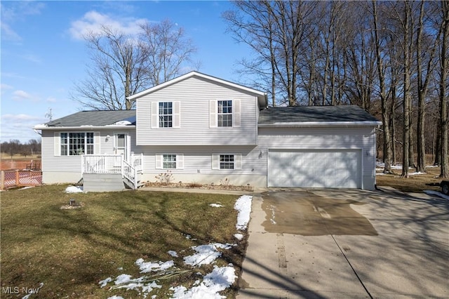 tri-level home featuring a garage, concrete driveway, and a front yard