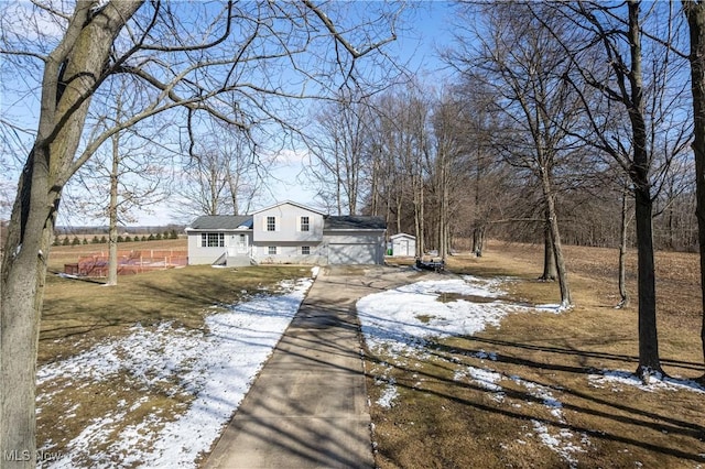 snowy yard with an outdoor structure and driveway