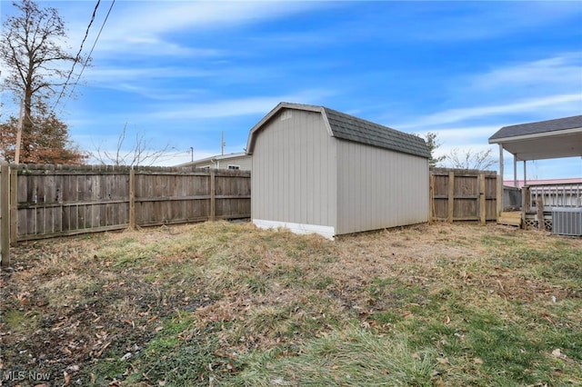 view of yard featuring a fenced backyard, an outdoor structure, a storage shed, and central air condition unit