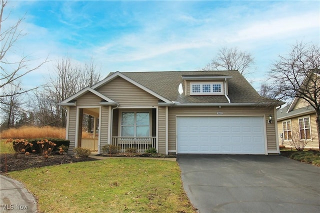 view of front of home with a shingled roof, aphalt driveway, an attached garage, covered porch, and a front lawn