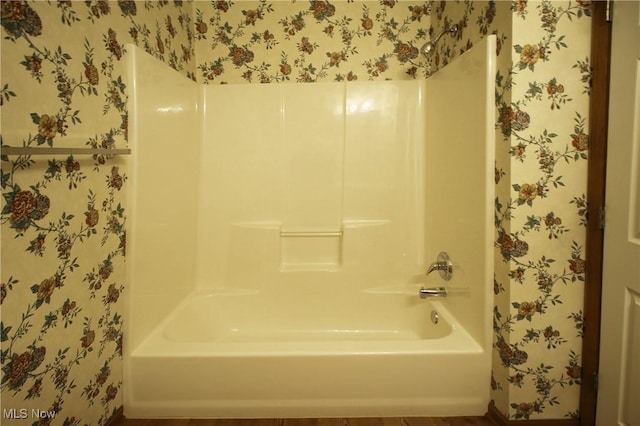 full bath with wallpapered walls and bathtub / shower combination