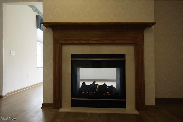 details with baseboards, wood finished floors, and a multi sided fireplace