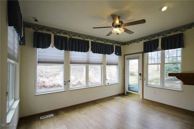 unfurnished sunroom with ceiling fan and visible vents