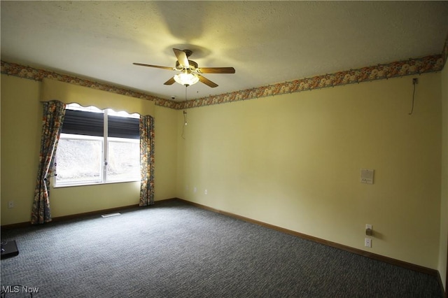 empty room with dark colored carpet, visible vents, ceiling fan, and baseboards