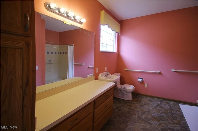 full bathroom featuring curtained shower, toilet, stone finish floor, vanity, and baseboards