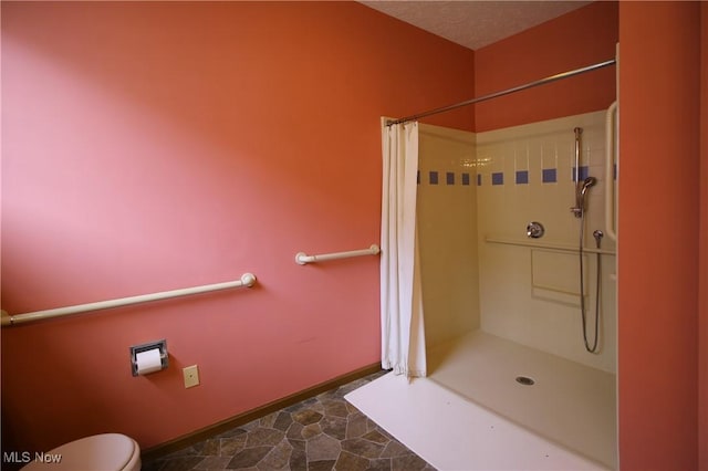 full bathroom with baseboards, stone finish flooring, toilet, and a shower with curtain