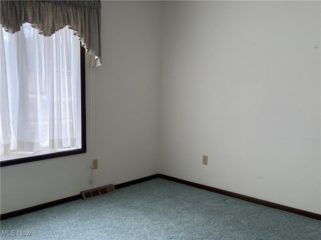 unfurnished room with visible vents, baseboards, and carpet