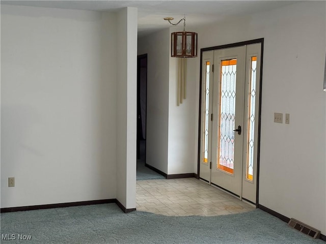 entryway featuring visible vents, carpet flooring, and baseboards