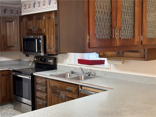 kitchen with a sink, appliances with stainless steel finishes, and light countertops