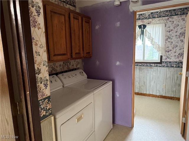 laundry area featuring cabinet space, independent washer and dryer, and wallpapered walls