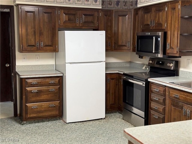 kitchen featuring light countertops, dark brown cabinets, open shelves, and stainless steel appliances