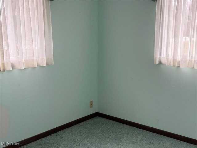 unfurnished room with baseboards