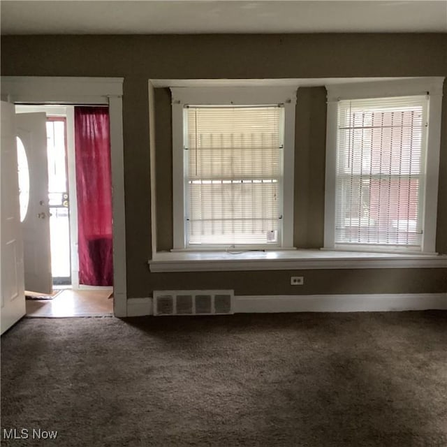 foyer featuring visible vents, baseboards, and carpet flooring