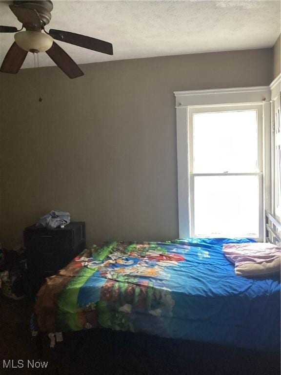 bedroom with a textured ceiling and ceiling fan