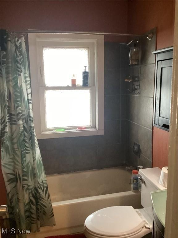 bathroom featuring shower / bathtub combination with curtain, toilet, and vanity